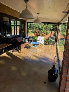 a screened in porch with a couch and a table at Mission House in Howick