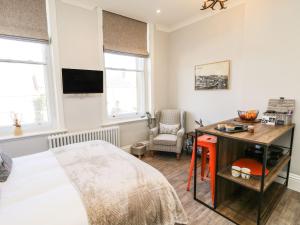 a bedroom with a bed and a desk and a tv at Lewis Hunton Suite in Saltburn-by-the-Sea