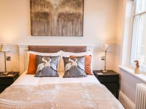 1 dormitorio con 1 cama con 2 pájaros en las almohadas en Lewis Hunton Suite en Saltburn-by-the-Sea