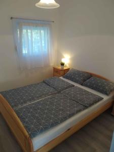 a large bed in a room with a window at Holiday home in Balatongyörök 42286 in Balatongyörök