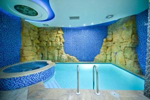 a bathroom with a tub with a rock wall at Spa Hotel Grace Forum in Yerevan