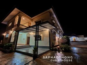 a villa with a swimming pool at night at Saphaothong guesthouse in Vang Vieng