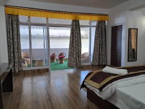 a bedroom with a bed and a large window at The Sherpa's Abode in Gangtok