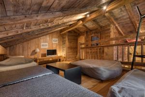 a bedroom with two beds and a desk in a cabin at Hôtel Les Servages d'Armelle in Les Carroz d'Araches