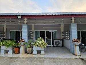 ein Haus mit Topfpflanzen davor in der Unterkunft สวนเมืองจันท์ รีสอร์ท in Chanthaburi