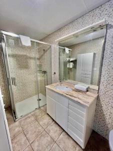 a bathroom with a sink and a shower and a mirror at Hostal Viena Plaza Nueva in Granada
