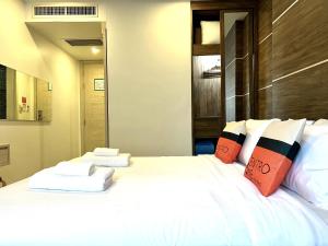 ein Schlafzimmer mit einem großen weißen Bett mit Kissen in der Unterkunft Centro One Bangla in Patong Beach