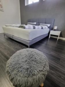 - une chambre avec un lit doté d'un tapis et d'un tabouret dans l'établissement Appartment Barbier, à Großefehn 