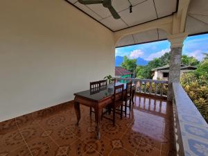 a dining room with a table and chairs on a balcony at Saphaothong guesthouse in Vang Vieng