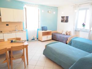 a room with two beds and a table and a kitchen at Mini-Appartamenti, Camere Lanterna Blu in Mombello Monferrato