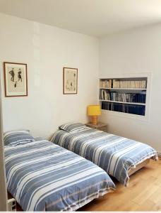 two beds sitting next to each other in a bedroom at Bel appartement à la Chetardière in Sainte-Gemme-dʼAndigné