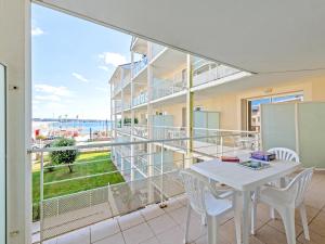 balcón con mesa, sillas y vistas al océano en Vacancéole - Le Domaine de Bertheaume, en Plougonvelin