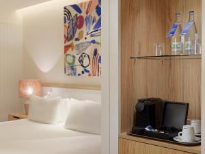 a hotel room with a bed and a tv on a shelf at H10 Croma Málaga in Málaga