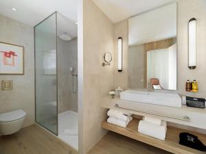 a bathroom with a sink and a shower and a toilet at H10 Croma Málaga in Málaga