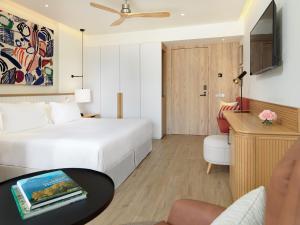 een hotelkamer met een wit bed en een tafel bij H10 Croma Málaga in Málaga