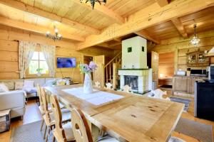 a kitchen and living room with a wooden table in a cabin at Dom Rajka in Stronie Śląskie