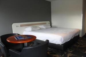 a hotel room with a bed and a table and chairs at Fletcher Stadshotel Den Haag in The Hague