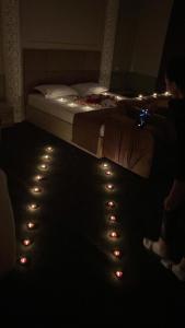 una persona seduta in una stanza con un letto illuminato di Sapphire hotels a Taraz