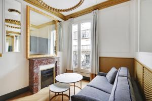 a living room with a couch and a fireplace at Pick A Flat's Apartments in Champs Elysées - Rue du Colisée in Paris