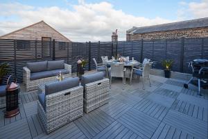 a patio with a table and chairs on a deck at Host & Stay - Oxford House in Harrogate