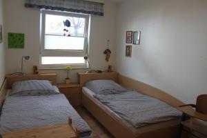 twee bedden in een kamer met een raam bij Fewo Strandrevier in Zingst