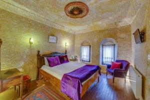 ウルギュップにあるCappadocia Abras Cave Hotelのベッドルーム1室(ベッド1台、椅子1脚付)