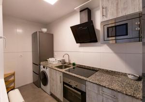 uma pequena cozinha com um lavatório e um frigorífico em Area Suites em Jove