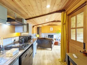 kuchnia i salon z kanapą w tle w obiekcie The Quail Cabin w mieście Kirdford