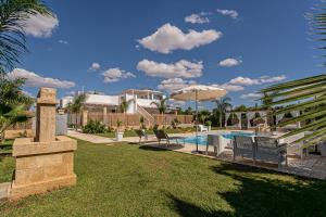 a resort with a pool and chairs and an umbrella at Resort Almaredamarra con piscina e idromassaggio sul mare in Torre San Giovanni Ugento