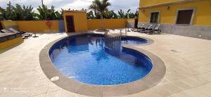 - une piscine dans un patio avec des chaises et un bâtiment dans l'établissement Trbol Trail Mountain La Palma Vistas Al Mar, à Tazacorte
