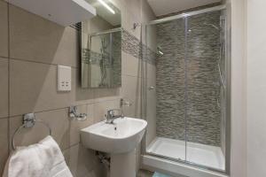 uma casa de banho com um lavatório e um chuveiro em Sliema Bedrooms with ensuite bathrooms em Sliema