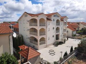 a large white building with a courtyard in a city at Pansion Dovodja in Vodice