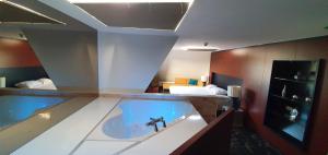 a bathroom with a bath tub with a sink at Fletcher Stadshotel Den Haag in The Hague