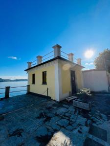 ein kleines gelbes Haus auf der Wasserseite in der Unterkunft boat house facing the lake in Orta San Giulio