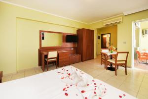 a bedroom with a bed and a dining room at Esmeralda Hotel in Kremasti