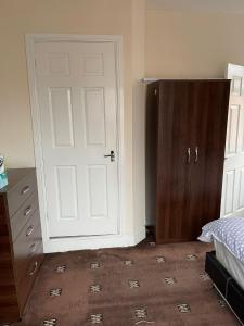 a bedroom with a white door and a wooden cabinet at 1 Bedroom Flat - Milligan Road Leicester in Leicester