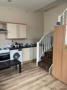 a kitchen with a staircase and a kitchen with a washing machine at 1 Bedroom Flat - Milligan Road Leicester in Leicester