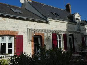 uma casa de tijolos brancos com portas e janelas vermelhas em Chambre d'hotes "Les Paturelles" em Fougères-sur-Bièvre