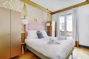 a bedroom with a large bed with towels on it at Pick A Flat's Apartments in Champs Elysées - Rue du Colisée in Paris