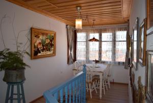 a dining room with a table and a blue staircase at Renovated Old Manor House With Yard in Arnaia