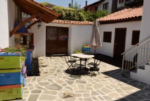 a patio with a table and an umbrella at Renovated Old Manor House With Yard in Arnaia