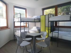 a room with bunk beds and a table and chairs at Ecostel Budaörs in Budaörs