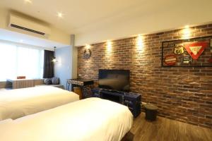 a hotel room with two beds and a brick wall at MU House in Taipei