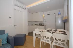 a kitchen and a dining room with a table and chairs at Residenza Leo in Bibione