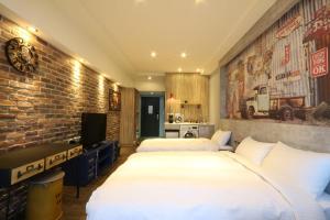 a bedroom with two beds and a brick wall at MU House in Taipei