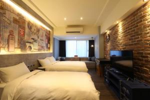 台北市にあるMU Houseのレンガの壁のホテルルームで、ベッド2台が備わります。