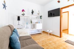 a living room with a couch and white shelves at El Pajero de Floreal in Villa de Mazo