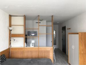 Habitación con una estantería de madera con microondas. en Studio Biarritz, 1 pièce, 2 personnes - FR-1-3-412, en Biarritz