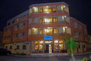 a large building with lights on in a parking lot at Hôtel La Palmeraie Saint Louis Sénégal in Saint-Louis