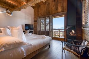 1 dormitorio con 1 cama grande y chimenea en Hôtel Les Servages d'Armelle, en Les Carroz d'Araches